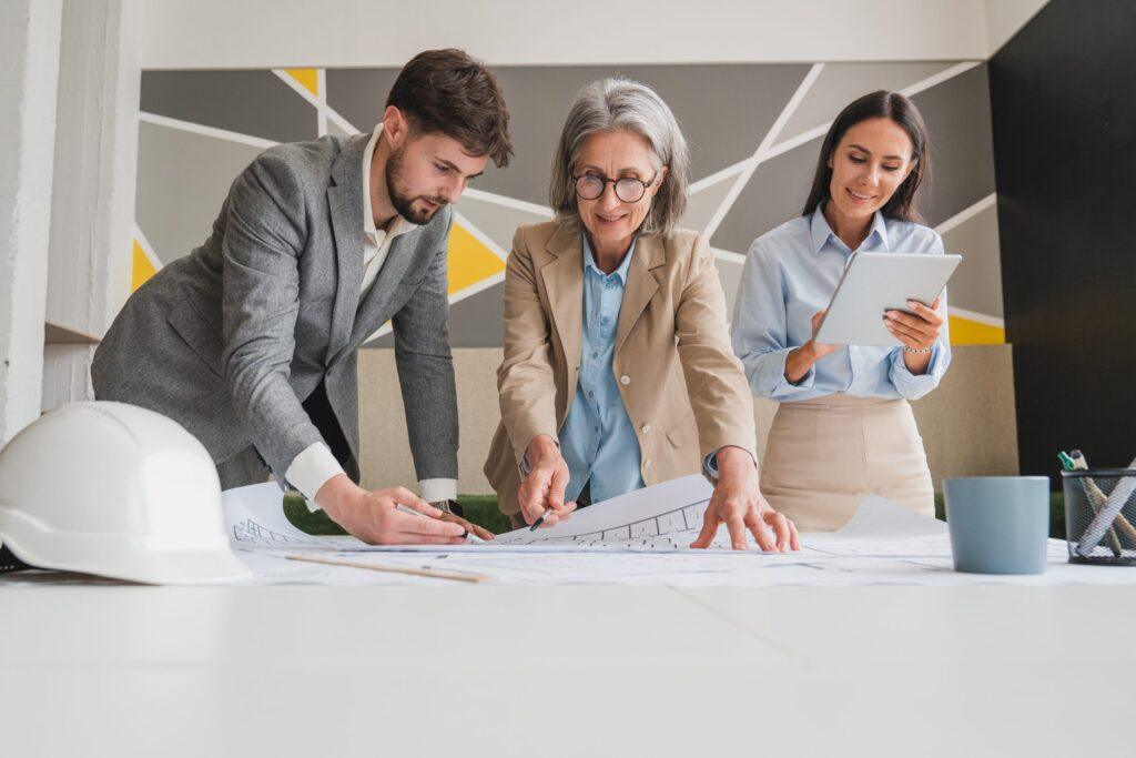 in architectural bureau: team of architects and engineers working on a building complex prototype project, using city model and computers running 3d cad software. residential or business district