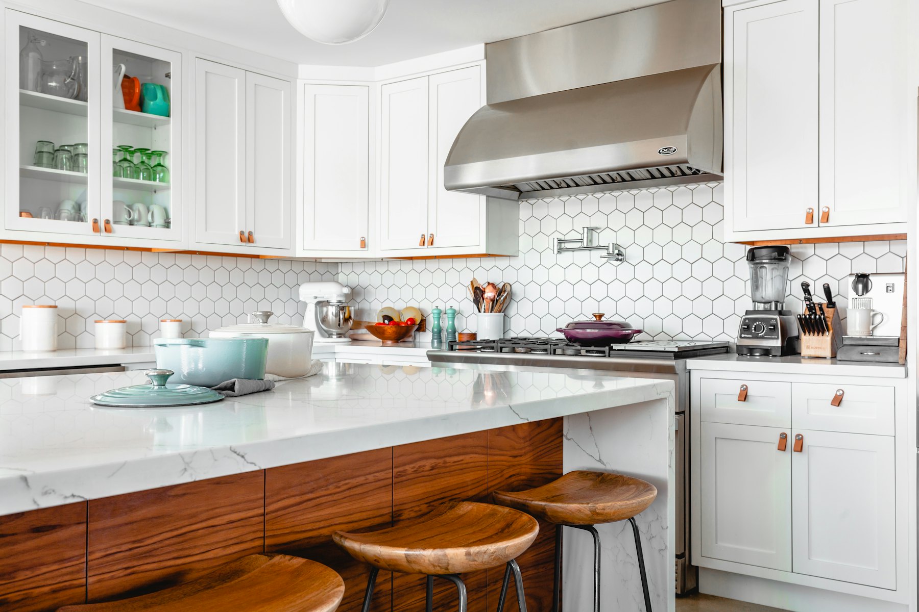 Clean, timeless kitchen design with durable stone and layered lighting