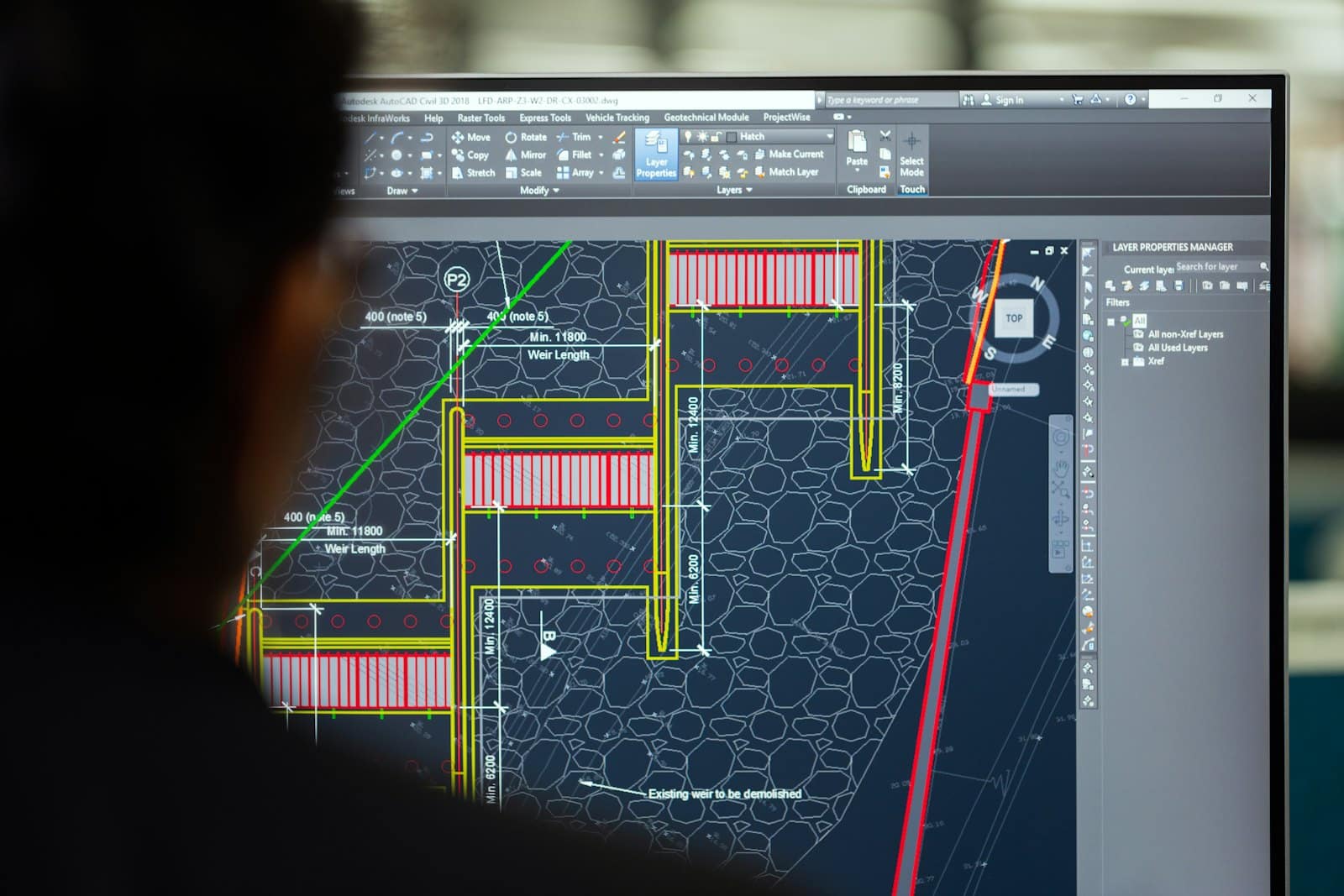 Engineer reviewing civil site drawings in AutoCAD Civil 3D on a monitor