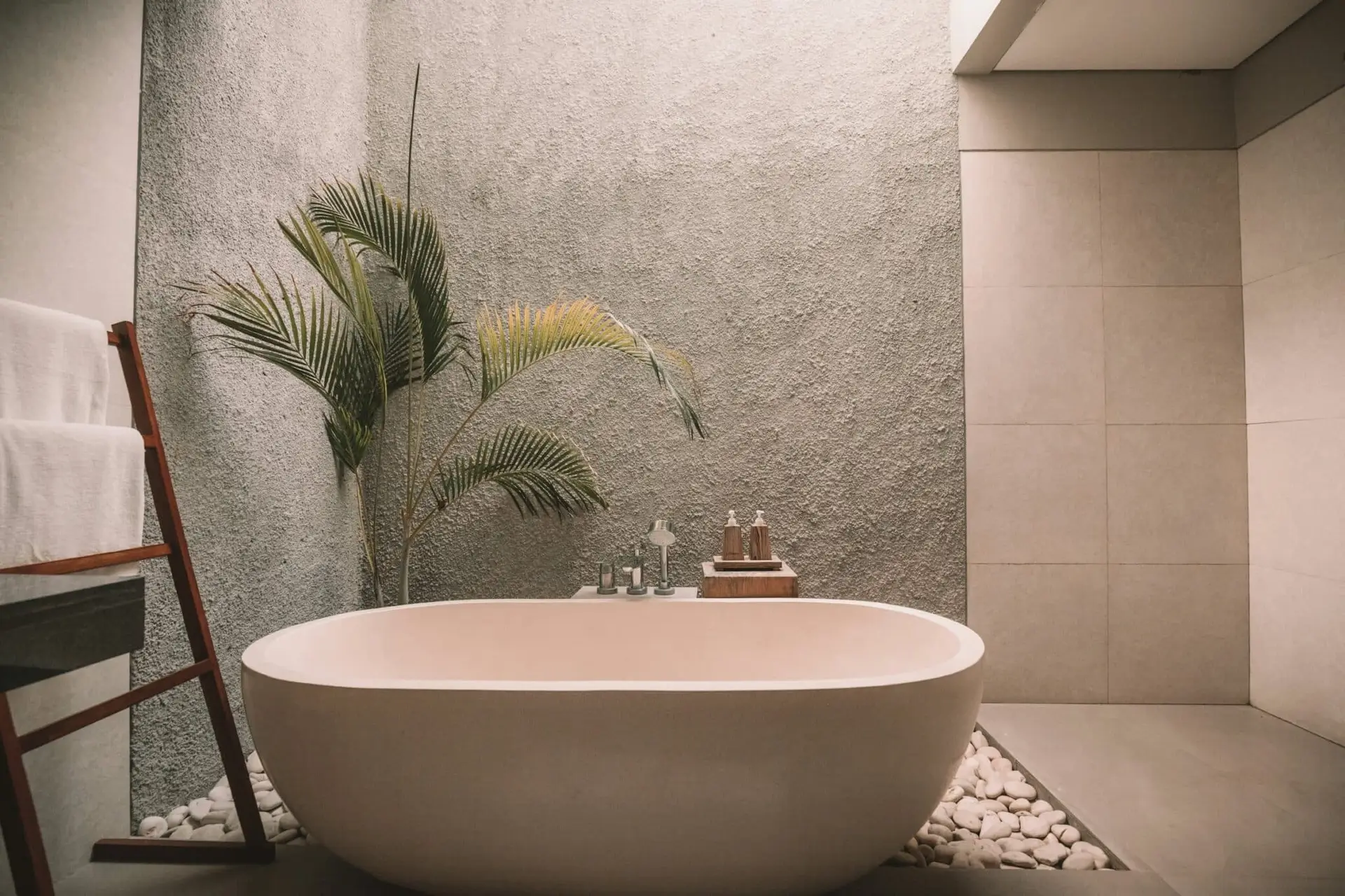 Spa-like coastal bathroom with natural stone, plaster, and soft biophilic lighting