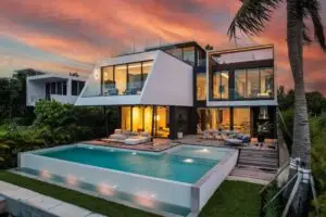 Modern two story waterfront home with swimming pool at sunset