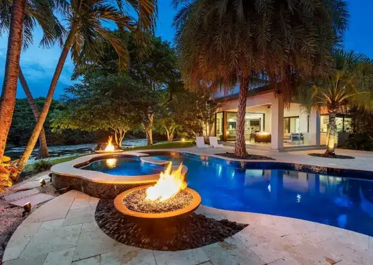 Private Resort Homes in South Florida: Pools, Spas, and Outdoor Kitchens - 2 Private resort home in South Florida with covered outdoor kitchen, dining, and lounge zones beside the pool